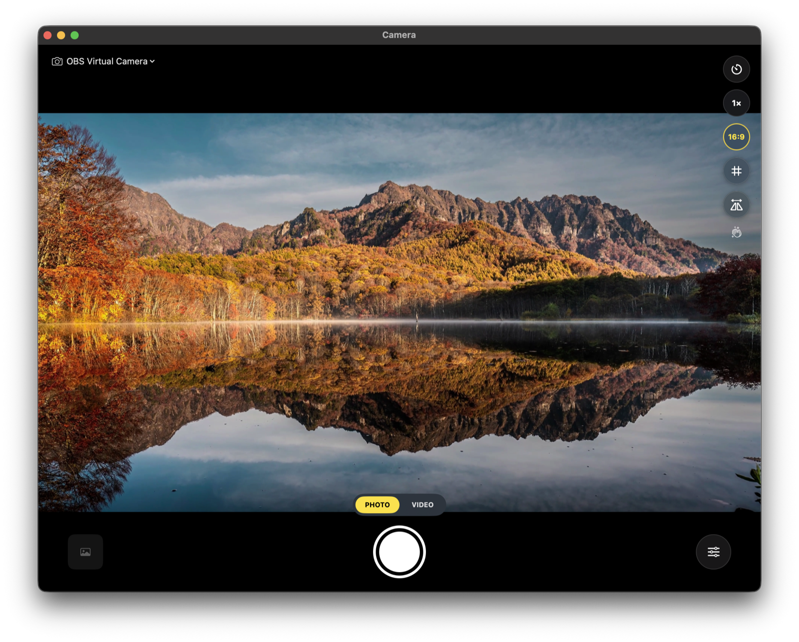 Camera main window: live mountain-lake preview with 16:9 aspect masks, zoom control, and iOS-style glass buttons